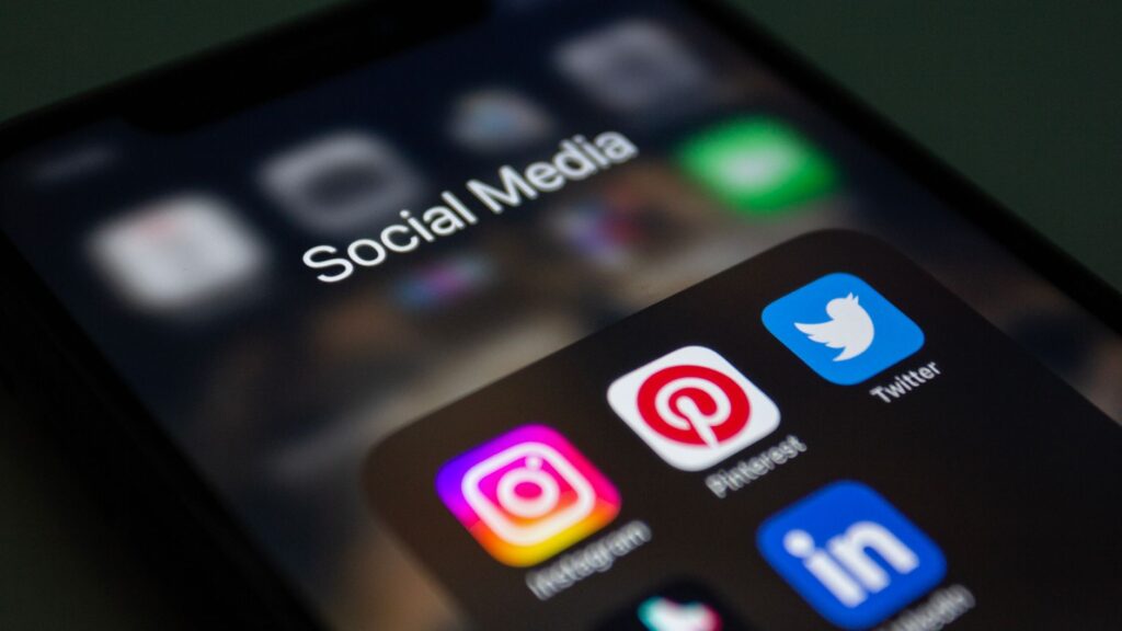 Smartphone mostrando apps de redes sociales y WhatsApp